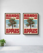 Hands Full of Apples art print in brown frame, installed on wall