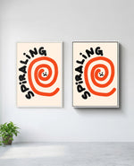 Spiraling art print in white frame, installed on wall